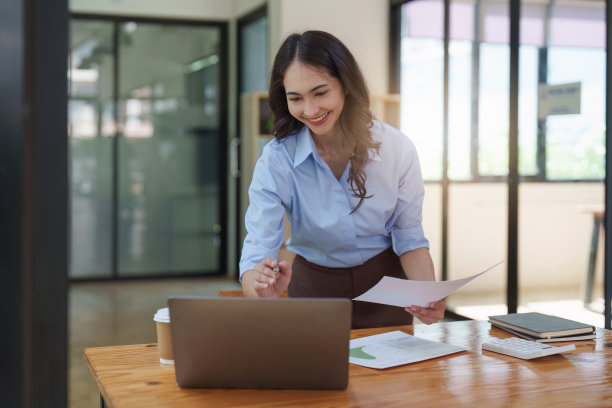 一位亚洲女性金融家工作，使用笔记本电脑，给一家金融公司做报告。会计与财务概念图片下载
