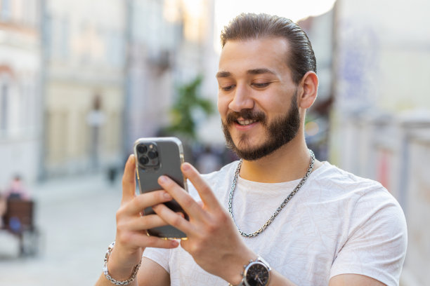 年轻男人用智能手机打字发短信浏览互联网完成工作看着镜头图片下载