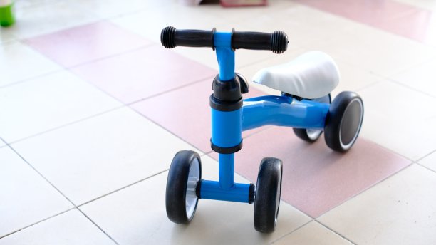 一辆蓝色的三轮车停在瓷砖地板上图片下载