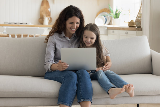 积极的母亲和可爱的学前班小女孩使用电脑图片下载