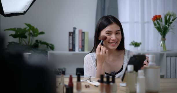 年轻美丽的亚洲女博主向我们展示了如何在家化妆图片下载