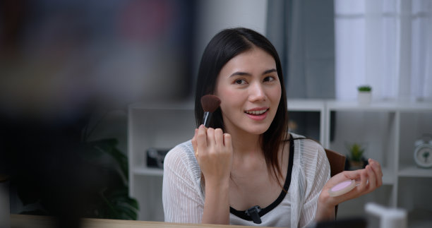 年轻美丽的亚洲女博主向我们展示了如何在家化妆图片下载