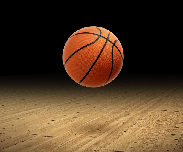 一个黑色背景的篮球放在硬木地板上图片下载