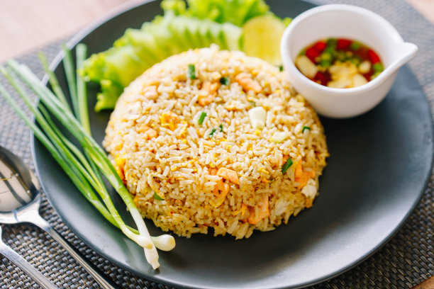 餐桌上黑色盘子里的鲑鱼炒饭。图片下载