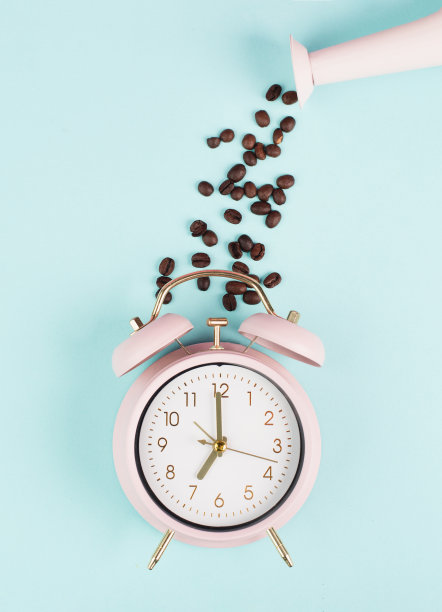 早上醒来，吃早餐，喝咖啡，闹钟上有烤豆和从喷壶里倒出来的心图片下载