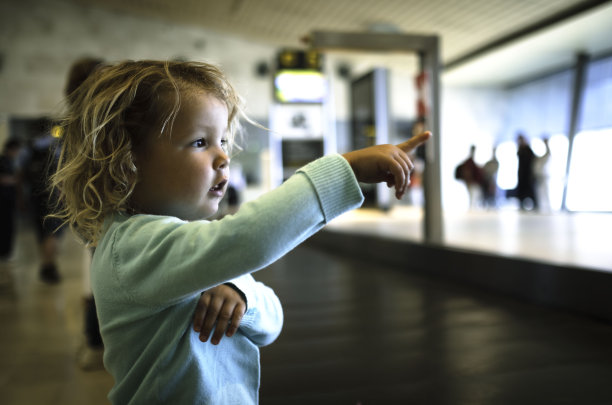 小女孩在机场行李传送带前等待。在机场候机楼等行李。图片下载
