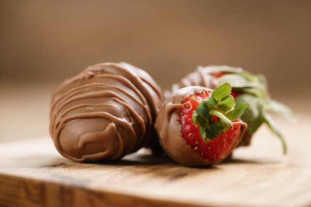 木板上覆盖着巧克力的草莓图片下载