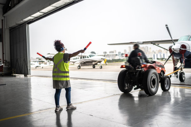 一名女子在机场用指挥棒给飞行员打信号图片下载