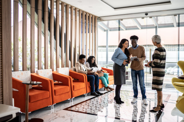 商务同事在机场贵宾休息室或办公室大厅交谈图片下载