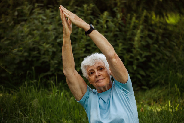 短发老人在户外练瑜伽和太极。老妇人在冥想。图片下载