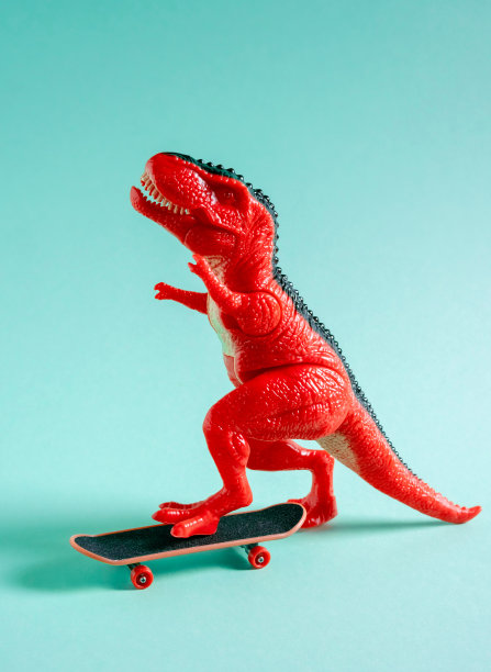 蓝色背景上的红色玩具恐龙滑板。图片下载