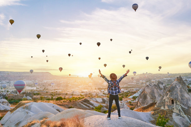 成功的旅行者在风景秀丽的安纳托利亚山谷里张开双臂的背影。美丽的目的地在nevesehir, goome图片下载