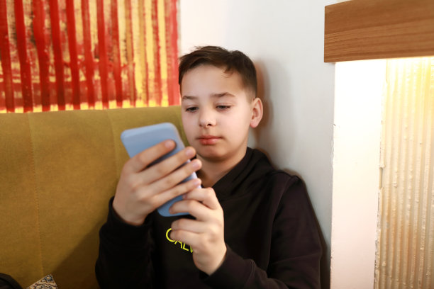 孩子在餐厅玩智能手机图片下载