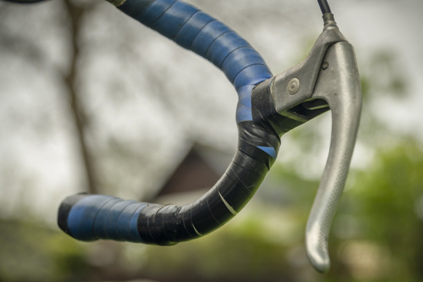 在绿色的春草天里，蓝色旧脏自行车的细节图片下载