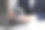 一个人在浅灰色的桌子上拿着放大镜靠近笔记本电脑，特写。在线搜索概念图片下载