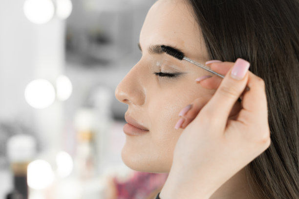 这张照片捕捉到了美容大师的精致工作，他熟练地矫正了眉毛的形状。客户可以对自己的专业护理和完美形象充满信心。图片下载