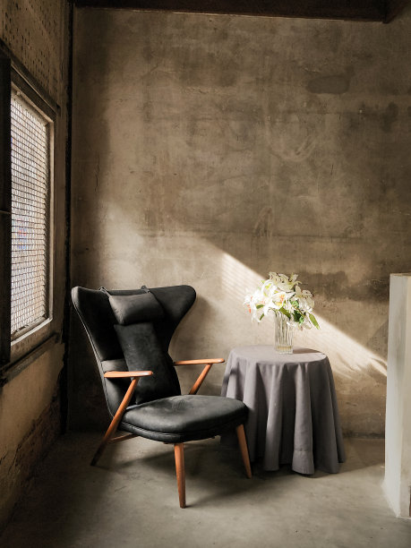 在房间的角落里，带着光影的椅子和花瓶的桌椅。图片下载