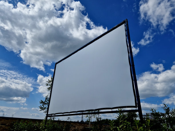 铝制舞台结构。大幅面白色屏幕，防水油布，公园户外电影院。用拉绳固定。天幕设置在公园、黑色、云彩、蓝天、项目、横幅上图片下载