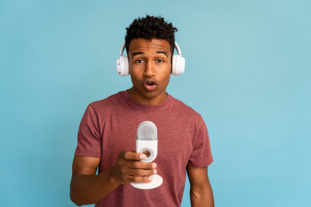 男子在录音棚使用耳机和麦克风。图片下载