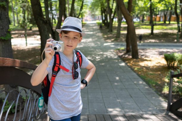 年轻的摄影师。男孩拿着数码相机拍照。图片下载