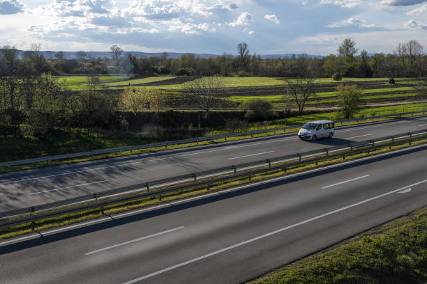 白色现代快递小件货物快递车在高速公路上快速行驶到城市郊区。图片下载