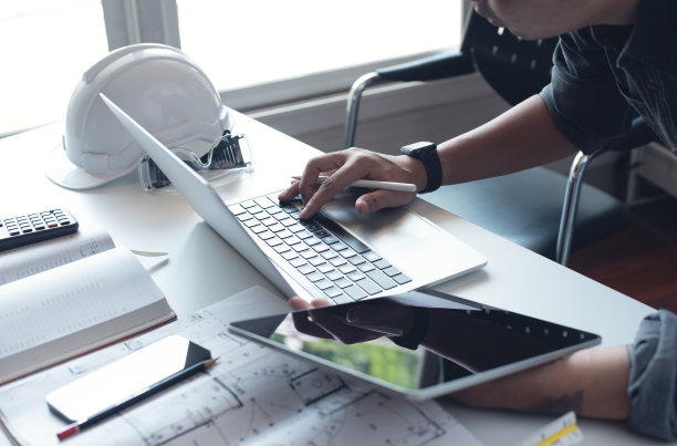 亚洲建筑师在建筑办公室使用笔记本电脑和数字平板电脑工作图片下载