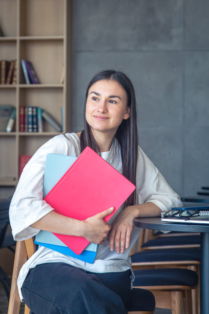 年轻的女学生坐在图书馆的笔记本电脑前。图片下载