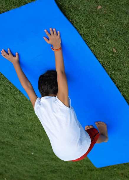 亚洲聪明孩子在社会公园户外做瑜伽姿势，儿童瑜伽姿势。做瑜伽和冥想练习的小男孩。图片下载