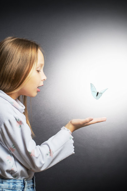 可爱的小女孩拿着蝴蝶。梦惊了美丽的小女孩。图片下载
