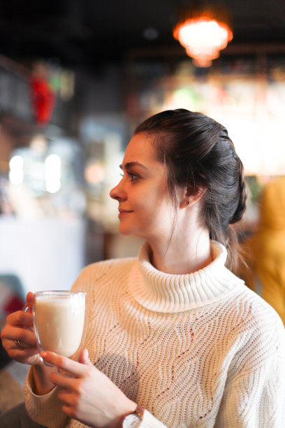 这个女孩正在喝咖啡。餐厅里的年轻女孩图片下载