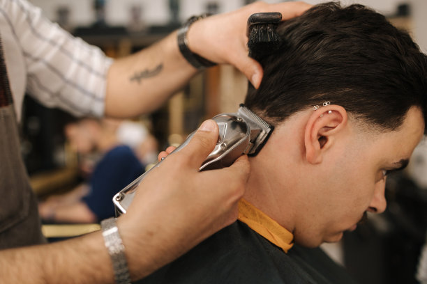 在柏柏尔店里，英俊的大胡子男子正在给自信的男顾客理发图片下载