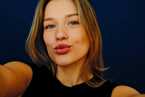 年轻美女对着镜头飞吻，自拍图片下载