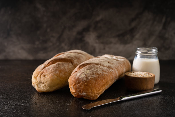 新鲜的自制手工法棍面包在质朴的背景与复制空间。迷你法棍面包。图片下载