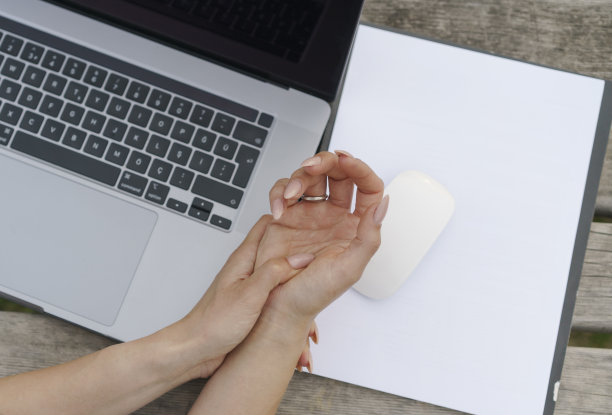 一位女商人因为使用笔记本电脑而痛苦地握着手腕图片下载