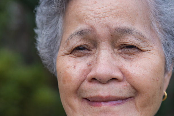 资深女性站在户外看着镜头微笑的特写。图片下载