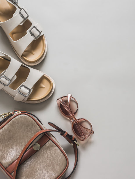 夏季女性配饰——舒适的凉鞋，太阳镜，浅灰色背景的皮革十字，俯视图图片下载