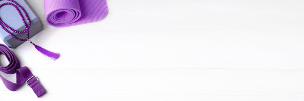 瑜伽练习的配件。薰衣草瑜伽垫，泡沫块，马拉珠和腰带在浅色背景的横幅文案空间。图片下载