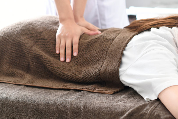 年轻女子在按摩床上接受治疗图片下载