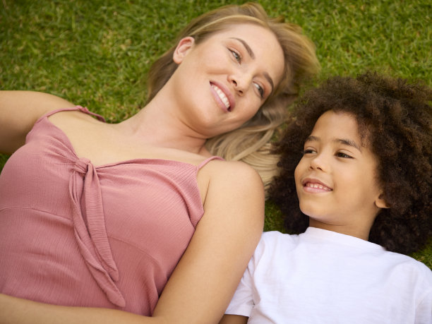 母亲和儿子一起躺在草地上的俯拍照片图片下载