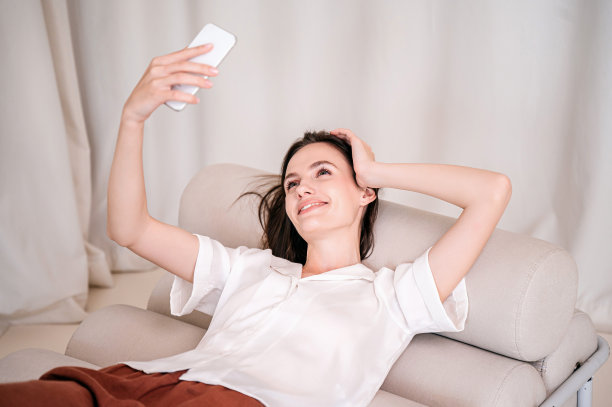 女人用她的现代智能手机，自拍，录制视频信息图片下载