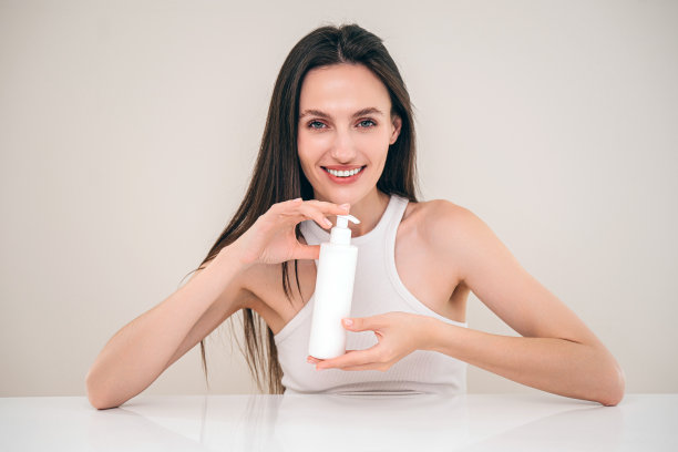 一名妇女在镜头前展示用于皮肤和身体护理的润肤霜和呵护产品图片下载