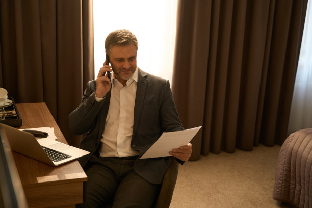 一个拿着文件打电话的成年男子图片下载