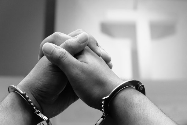 手铐铐在男人的手臂上。图片下载