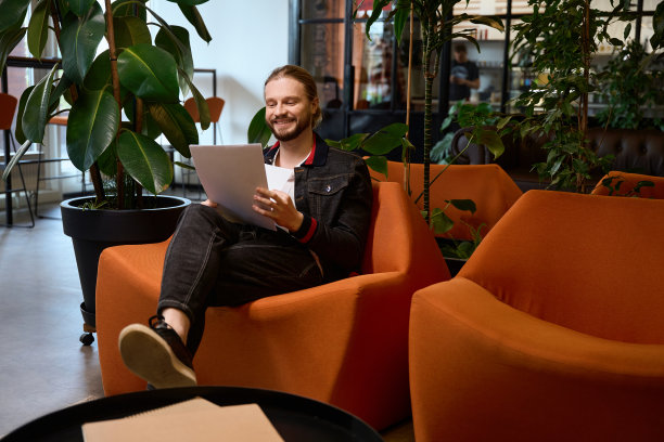 大胡子的自由职业者坐在扶手椅上拿着工作文件图片下载