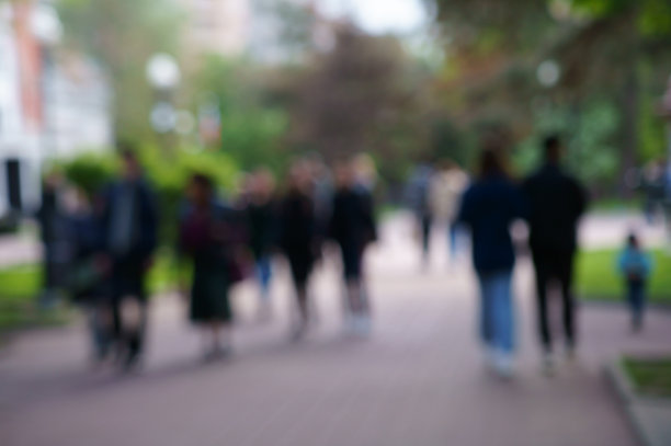模糊的背景。人们沿着城市的街道走着。图片下载