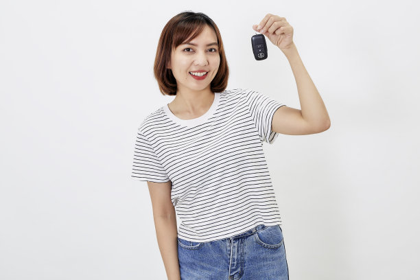 肖像美丽的年轻商务亚洲妇女与车钥匙在白色孤立的背景图片下载