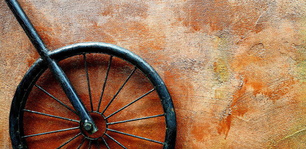 黑色铁或钢轮挂在棕色粗糙的墙壁与右复制空间。图片下载