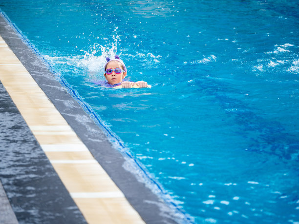 亚洲儿童或小女孩穿着泳装在游泳池学习，在踢板上学习和训练游泳图片下载
