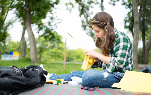 小女孩在公园度假，用纸做鸟嘴的手艺可以用你的手指移动你的嘴。图片下载