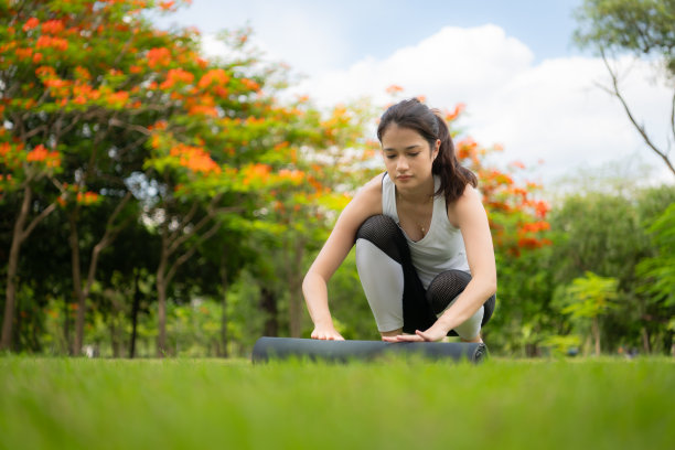 年轻女性在城市公园进行户外活动，瑜伽是她选择的活动。图片下载